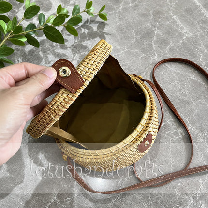 Lovely round rattan crossbody bag with inlaid mother of pearl for a youthful look.