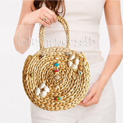 Boho round water hyacinth tote adorned with seashell embellishments.