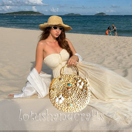 Boho round water hyacinth tote decorated with seashell embellishments.