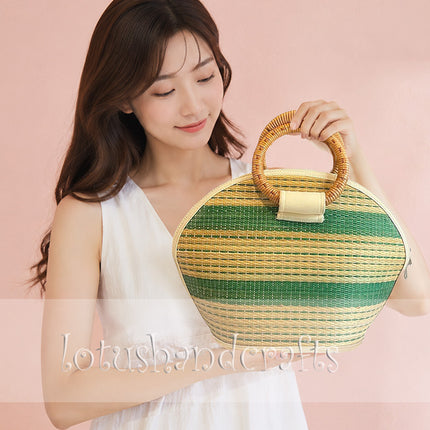 Handmade seagrass straw handbag with rattan handle in a half moon woven tote style.