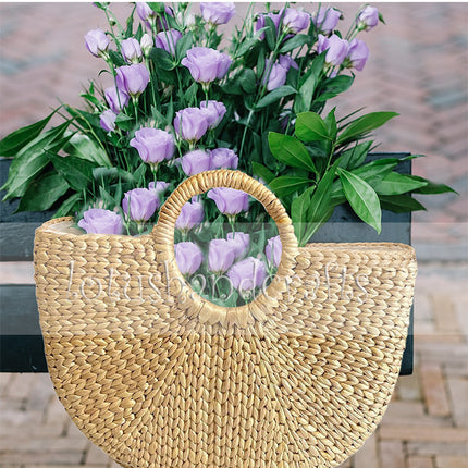 Handwoven half moon seagrass tote for a chic beach look.