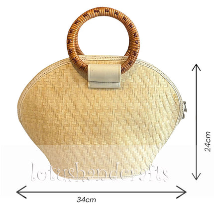 Handwoven seagrass handbag with round bamboo handles and seashell accents.