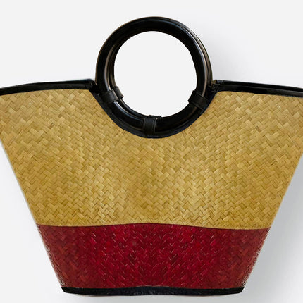 Handwoven seagrass tote bag with round black handle in crimson red.