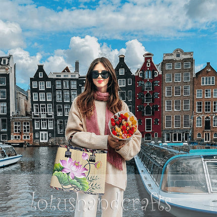 Handmade woven seagrass tote bag with hand-painted lotus blossom artwork.