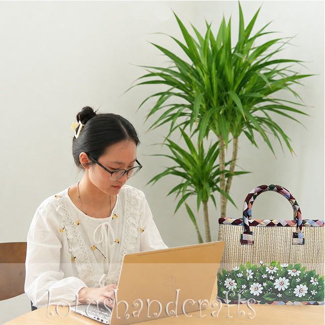 Handwoven seagrass tote bag with a cute hand painted wild daisy meadow floral design.