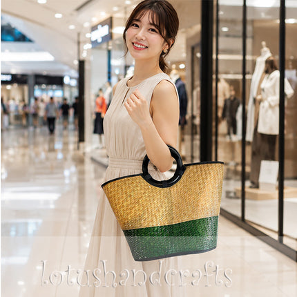 Handwoven seagrass tote bag with round black handle in natural and forest green.