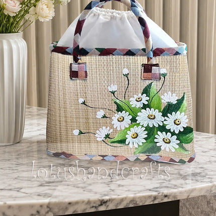 Handwoven seagrass tote bag with a hand painted white daisy bouquet.