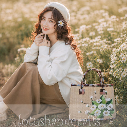 Handwoven seagrass tote bag with a hand painted white daisy bouquet, youthful.