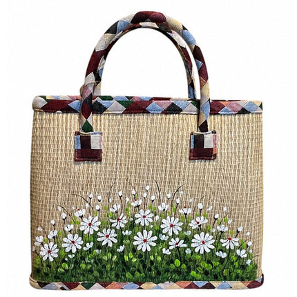 Handwoven seagrass tote bag with a cute hand-painted white wildflower meadow.