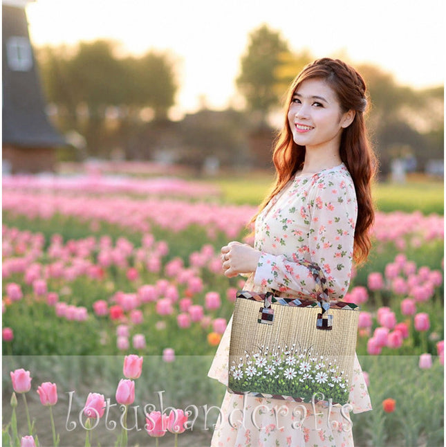 Handwoven seagrass tote bag featuring a hand-painted white wildflower meadow.
