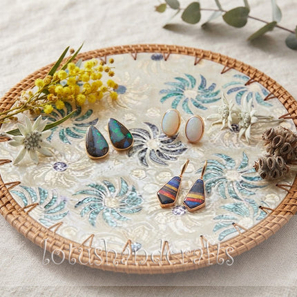 Handcrafted round charger plate with vibrant turquoise and blue spiral flowers, creating an elegant botanical-inspired design.