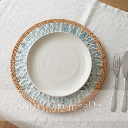 Artisan-made mother of pearl charger plate featuring a striking turquoise sunburst leaf pattern surrounded by a natural rattan border.