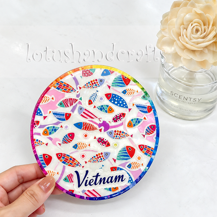 A detailed view showcasing the unique arrangement of differently patterned fish, colorful geometric elements, and the distinctive “Vietnam” lettering across the coaster.