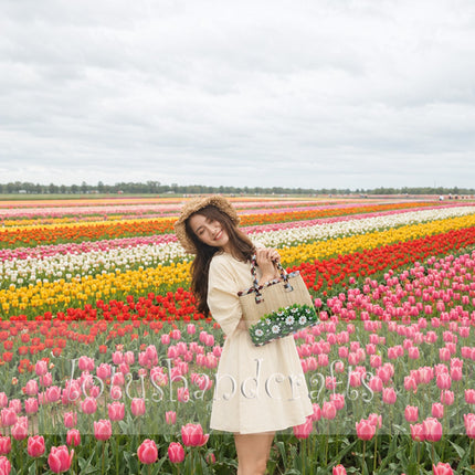Handmade woven seagrass tote bag with a hand-painted wild daisy meadow floral design.