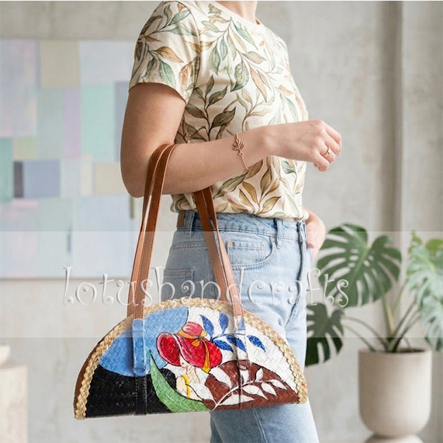 This youthful woven grass half moon bag featuring painted lady art elevates your everyday style.